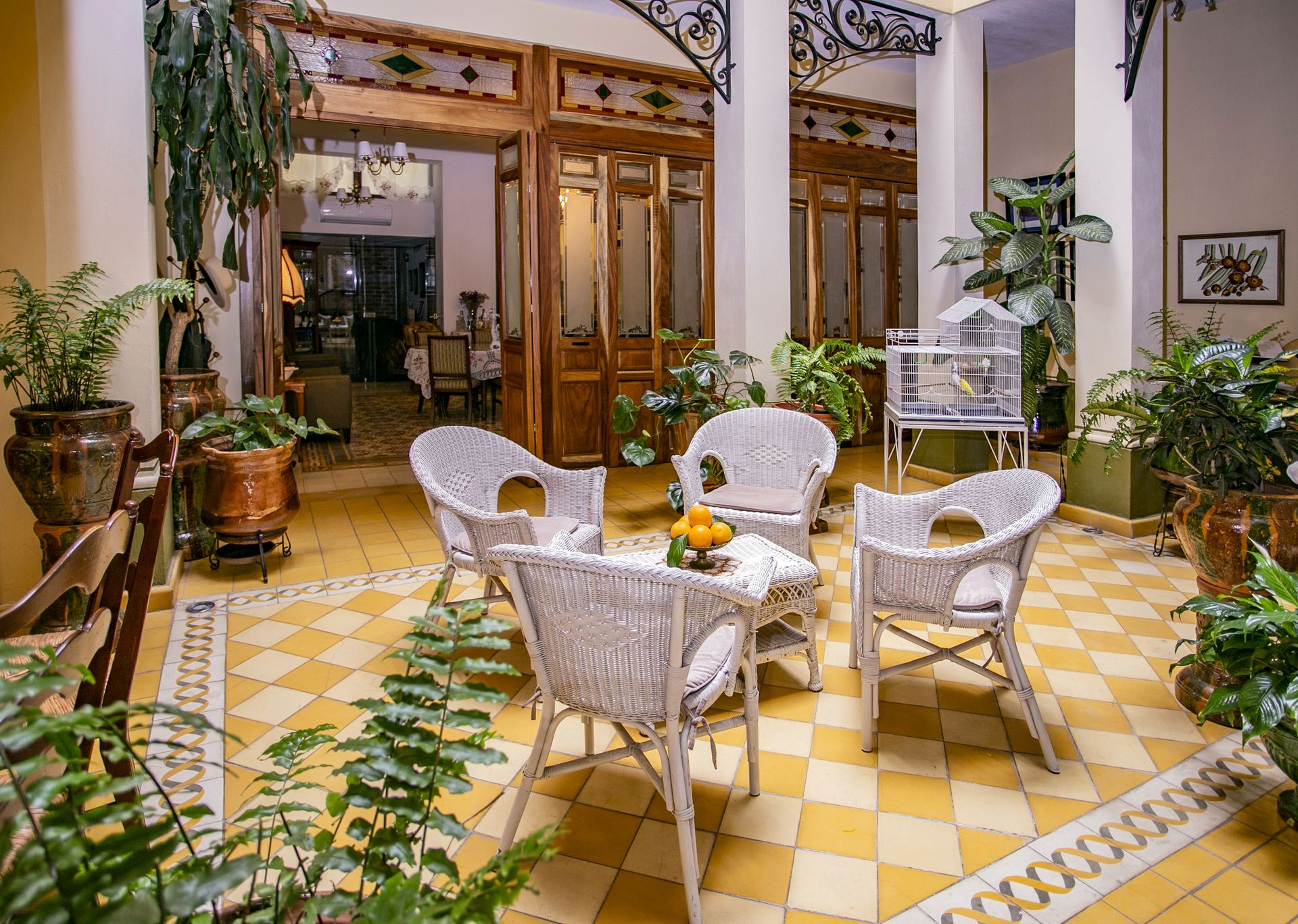 Corredor de Grand Casa Naranjos con sillas de mimbre y naranjas